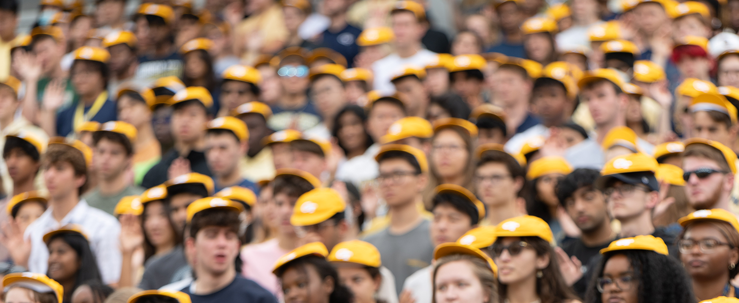 Blurred faces of Tech students wearing RAT caps during the fall 2022 convocation.