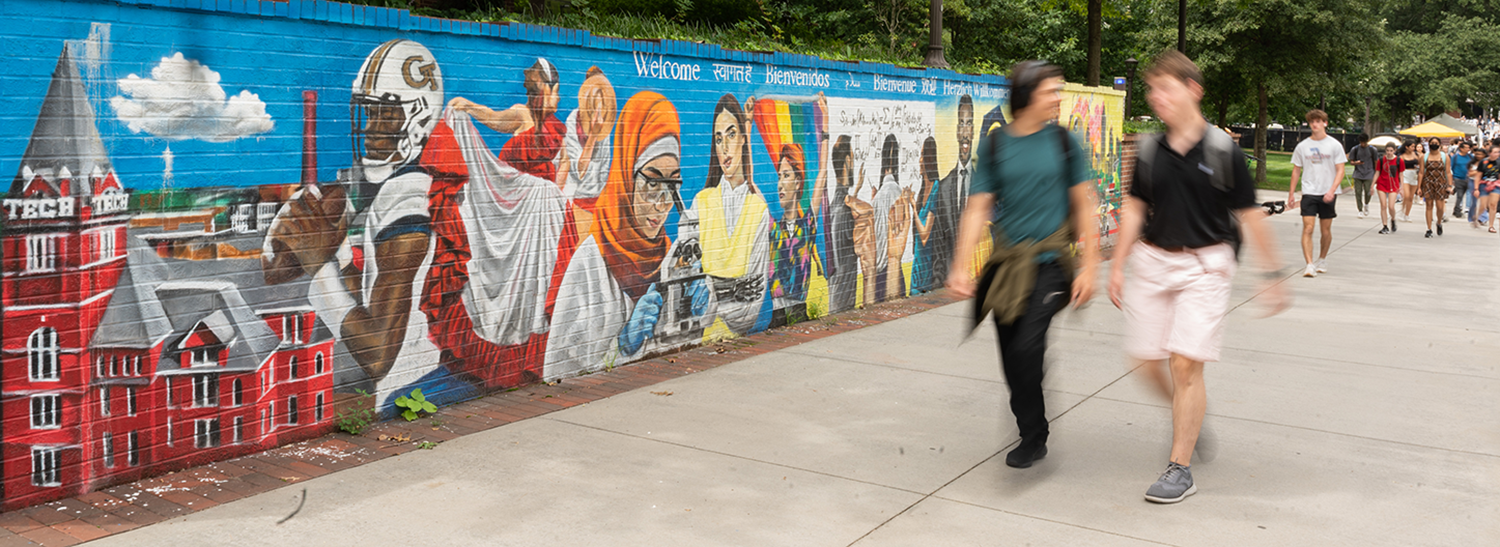 Tech students walking at Skiles Walkway near the Welcome mural.
