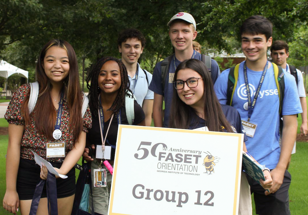 A group of Tech students. One is holding a sign that reads: 50 Faset Group 12.