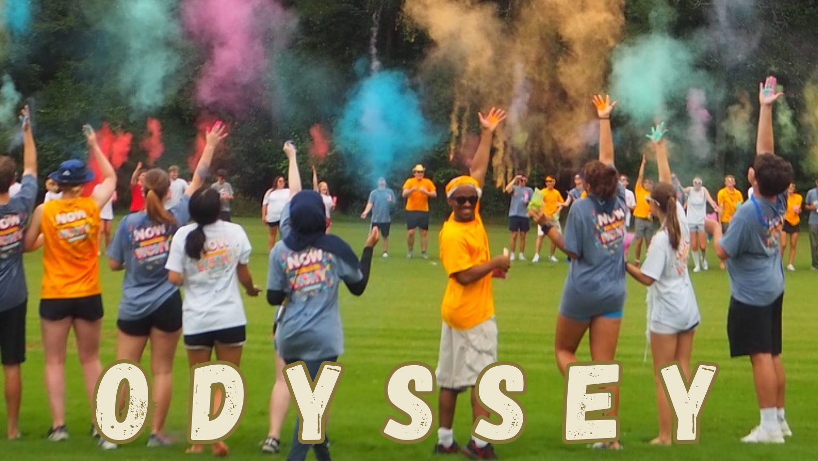 A group of student throwing color powder in the air at wreck camp odyssey